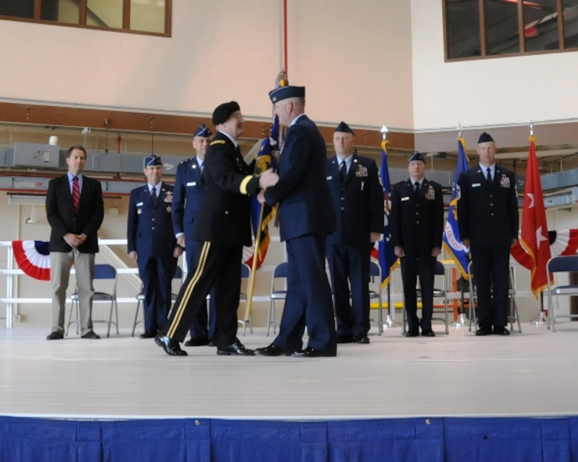 Maj. Gen. Matthew Quinn, Adjutant General of Montana (left), passes a new wing guidon to Col. J Peter Hronek, 120th Airlift Wing commander, during a change of mission ceremony at the Montana Air National Guard May 31.  The wing officially changed from a fighter wing to an airlift wing on March 1. (National Guard photo/Staff Sgt. Michael Touchette)