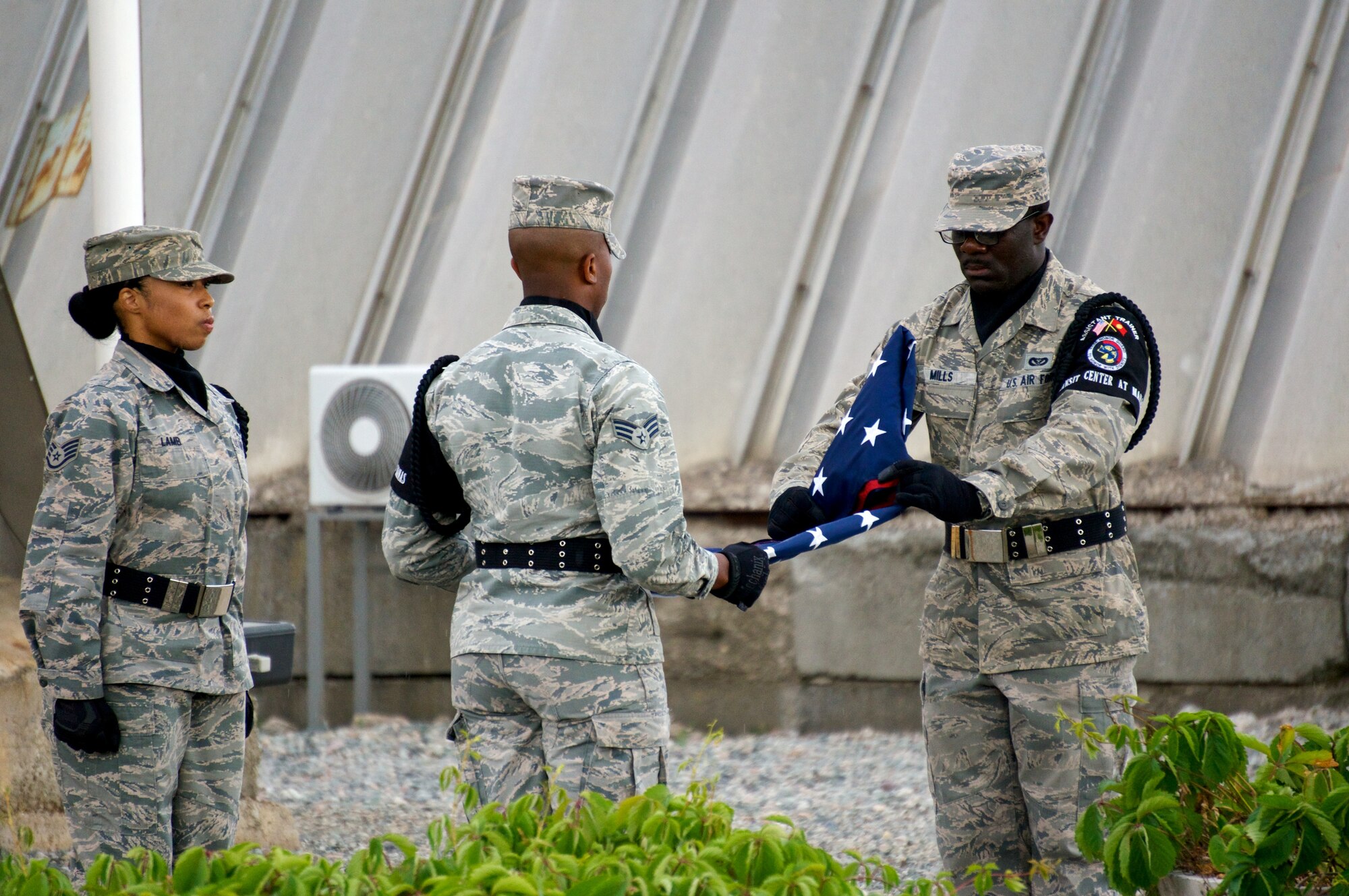 Honor Guard Airmen fold the American flag at the 376th Air Expeditionary Wing inactivation ceremony at Transit Center at Manas, Kyrgyzstan, June 3, 2014. For more than 12 years, the American military has operated out of the Transit Center at Manas. It served as the premier transportation and logistics hub supporting operations in Afghanistan. (Photo Courtesy of Capt. Cory O'Brien)  