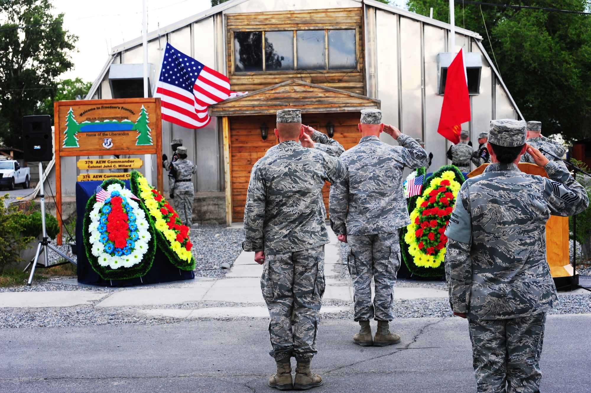 Airmen salute the American flag during a retreat as part of the 376th Air Expeditionary Wing inactivation ceremony at Transit Center at Manas, Kyrgyzstan, June 3, 2014. The 376th AEW was designated to stand up and sustain operations at the Manas International Airport, Kyrgyz Republic on Dec. 21,2001. Since its arrival, the total economic impact of the Transit Center in Kyrgyz Republic totals an estimated $809 million. (U.S. Air Force Photo/Lt. Col. Max Despain)