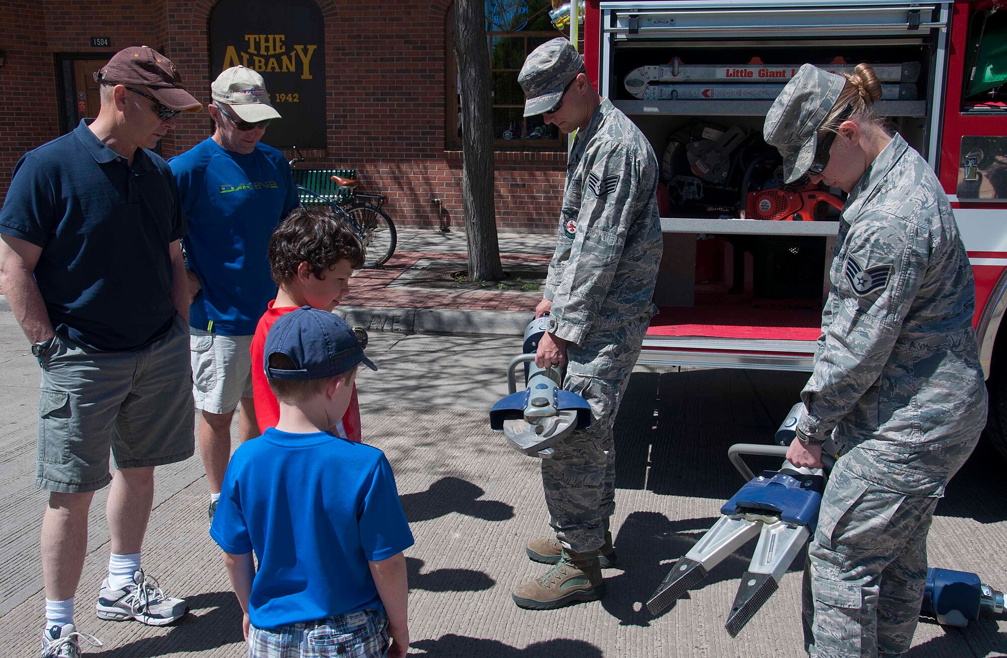 140531-F-HM052-085 Staff Sgt. Alex Klinger, 90th Civil Engineer Squadron Fire Department fire crew chief, and Staff Sgt. Kelsey Raile, 153rd Civil Engineer Squadron Fire Department fire fighter, present some of the tools they use in emergency situations May 31 during the Armed Forces Day event in the Cheyenne Depot. The 90th Missile Wing and the Wyoming Air National Guard teamed up to provide information to the public on the day-to-day activities they perform and the mission they achieve. (U.S. Air Force photo by 2nd Lt. Christen Ornella)