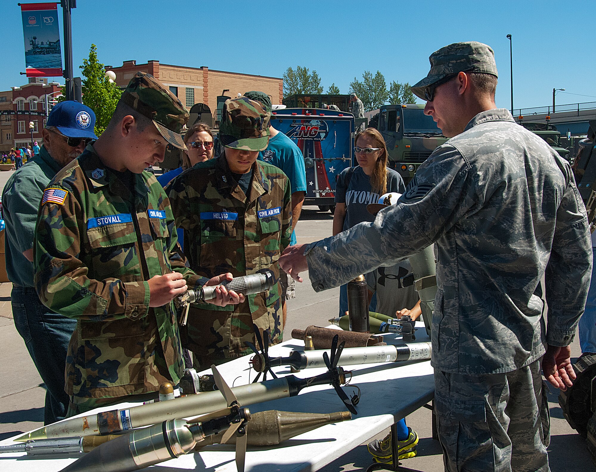 140531-F-CP692-013 Staff Sgt. Cory Ahlf, 90th Civil Engineer Squadron Explosive Ordinance Disposal technician, explains various explosives to Austin Helvig and Bowen Stovall, Cheyenne Civil Air Patrol, May 31 during an Armed Forces Day event in the Cheyenne Depot. Military personnel set up informational booths and displays to provide information to the local populace. (U.S. Air Force photo by Capt. Eydie Sakura)