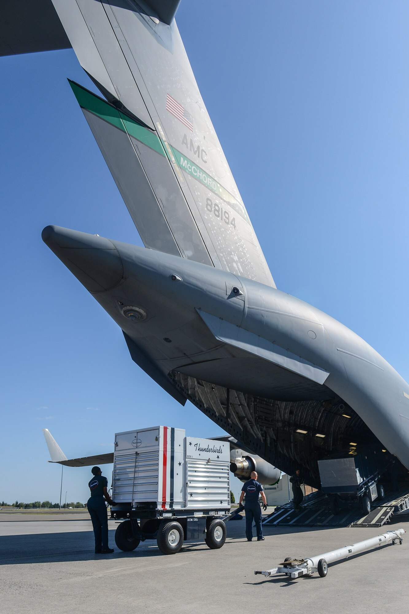 Members of the U.S. Air Force Thunderbirds support team work alongside 4th Airlift Squadron loadmasters based at Joint Base Lewis-McChord, Wash., June 2, 2014, to load Thunderbirds support equipment onto a McChord C-17 Globemaster III at Fairchild Air Force Base, Wash. Fairchild hosted the Thunderbirds during SkyFest 2014, the base's air show and open house, and the McChord aircraft and crew transported the Thunderbirds support personnel and equipment to their home base of Nellis AFB, Nevada, after the event.