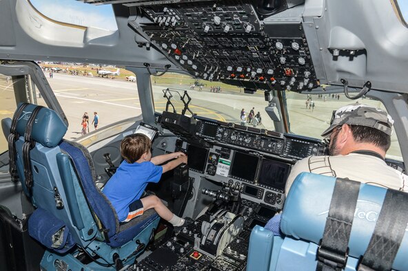 A child struggles to move the control stick on a C-17 Globemaster III static display May 31, 2014, while attending SkyFest 2014 at Fairchild Air Force Base, Wash. SkyFest is Fairchild's air show and open house and this year's two-day event hosted approximately 210,000 visitors to the base. (U.S. Air Force photo/Tech. Sgt. Sean Tobin)