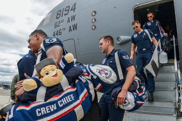 Members of the U.S. Air Force Thunderbirds support team are greeted by the Thunderbirds pilots May 29, 2014, as they exit a McChord C-17 Globemaster III at Fairchild Air Force Base, Wash. The C-17 transported 51 members of the demonstration team and 50,000 pounds of their equipment from Colorado Springs, Colo., to Fairchild to participate in Fairchild's SkyFest 2014. (U.S. Air Force photo/Tech. Sgt. Sean Tobin)