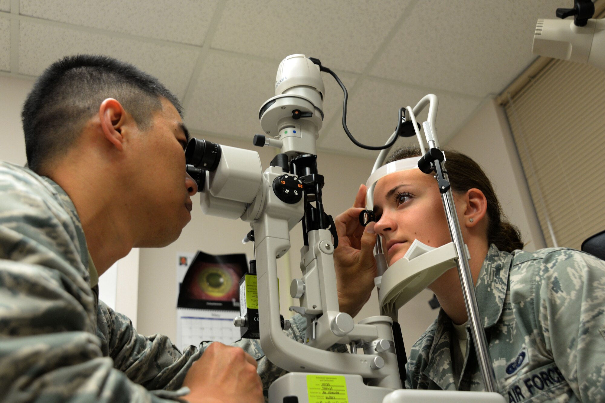 U.S. Air Force Capt. (Dr.) Lynh Nguyen, 20th Aerospace Medical Squadron optometry flight commander, uses a slit lamp to inspect the eyes of Airman 1st Class Emma Makransky, 20th Force Support Squadron food service specialist, at Shaw Air Force Base, S.C., May 29, 2014. The 20th AMDS Optometry Clinic currently has two doctors responsible for approximately 14,000 Tricare beneficiaries. (U.S. Air Force photo by Airman 1st Class Michael A. Cossaboom/Released)