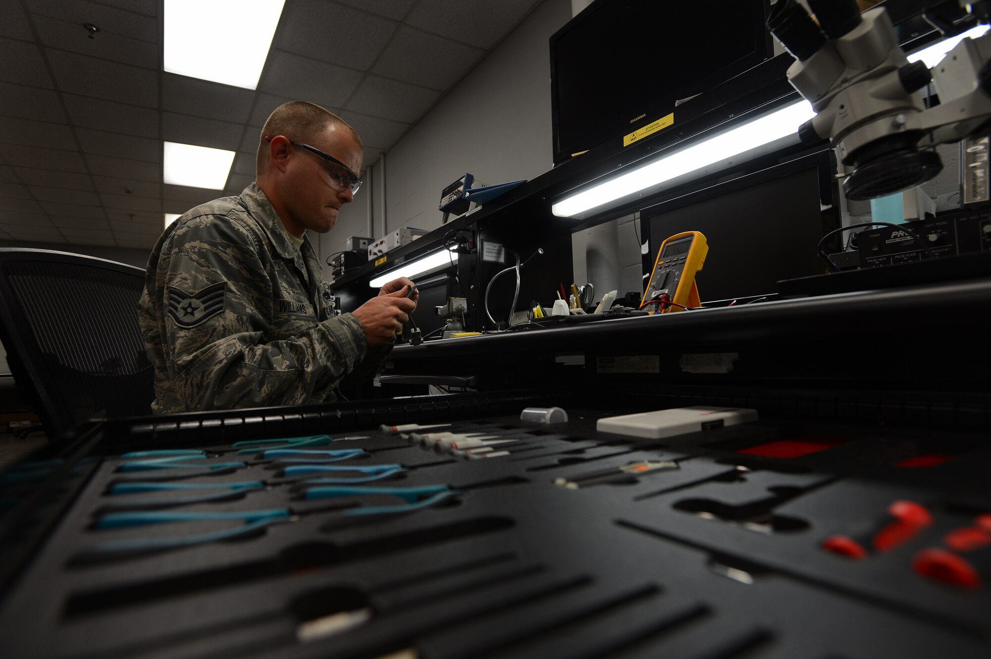 U.S. Air Force Staff Sgt. Scott Williams, 20th Maintenance Group Air Force Repair Enhancement Program technician, cuts a wire rubber casing while determining its damage at Shaw Air Force Base, S.C., May 21, 2014. Williams, one of three 20th Fighter Wing AFREP technicians, fixes approximately two and 10 broken parts a day, potentially saving thousands of dollars each day. (U.S. Air Force photo by Airman 1st Class Jensen Stidham/Released)