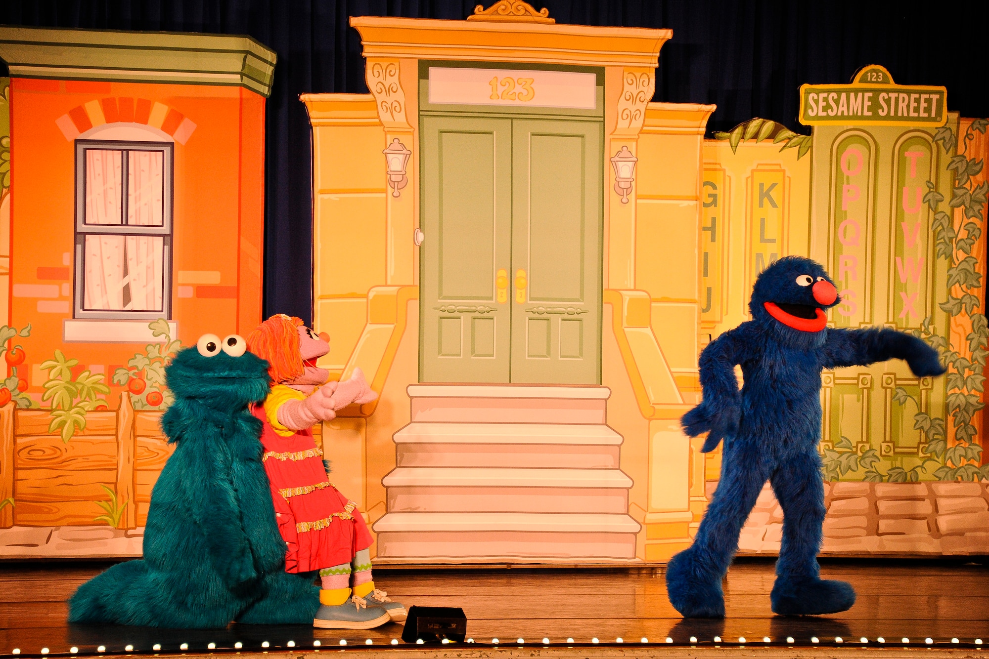 The Cookie Monster, Katie, a Sesame Street military child actress, and Grover perform for military and family members at the Sesame Street and USO Experience tour welcomes attendees to one of four shows during a two-day period at Joint Base McGuire-Dix-Lakehurst, N.J., May 28, 2014. The show was designed to shine a light on difficult situations a military child may face while allowing parents the opportunity to address stressful situations that may arise while serving in the armed forces. (U.S. Air Force photo by Staff Sgt. Scott Saldukas/Released)