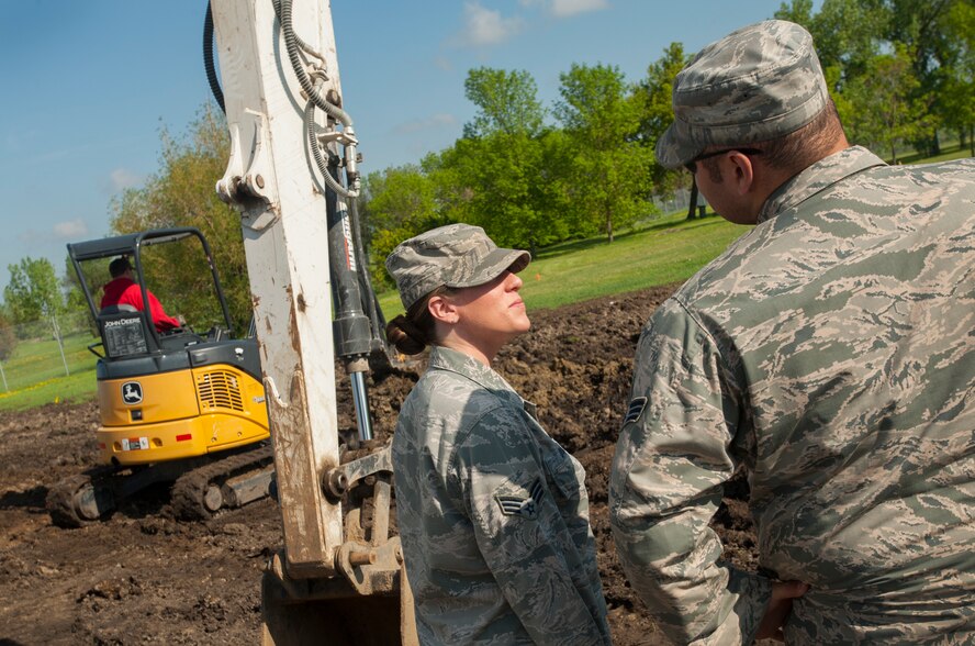 Senior Airman Megan Dohm, 5th CONS contracting officer, talks to 5th Civil Engineer Squadron engineering assistant Senior Airman Kasey Kay at a construction site at Minot Air Force Base, N.D., June 3, 2014. Dohm is currently overseeing renovations at the golf course on base. (U.S. Air Force photo/Airman 1st Class Apryl Hall)