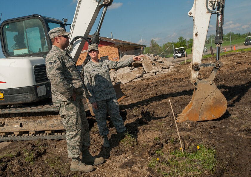 Senior Airman Megan Dohm, 5th CONS contracting officer, talks to 5th Civil Engineer Squadron engineering assistant Senior Airman Kasey Kay at a construction site at Minot Air Force Base, N.D., June 3, 2014. Dohm is currently overseeing renovations at the golf course on base. (U.S. Air Force photo/Airman 1st Class Apryl Hall)