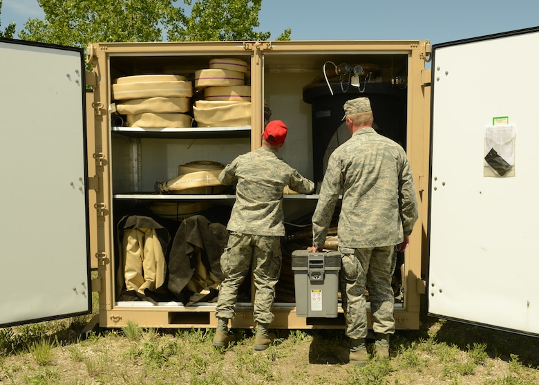 Two 219th RED HORSE Squadron Airmen set up a self-generated water system during a field training exercise at Malmstrom Air Force Base. The water system has the capability to produce 1,500 gallons of drinkable water every hour. (U.S. Air Force photo/Senior Airman Katrina Heikkinen)