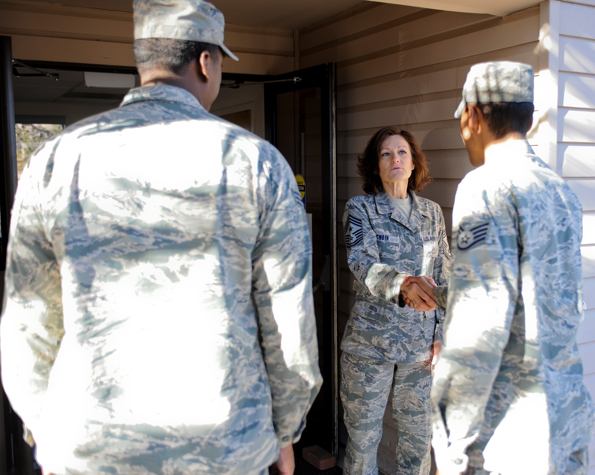 U.S. Air Force Chief Master Sgt. Dawna Cnota, 355th Fighter Wing command chief, greets Airmen as they arrive for the pancake social during a Comprehensive Airman Fitness Day at Davis-Monthan Air Force Base, Ariz., June 2, 2014. During this CAF Day, the Chiefs’ group served and cooked more than 600 pancakes for more than 100 Airmen. (U.S. Air Force photo by Senior Airman Sivan Veazie/Released)