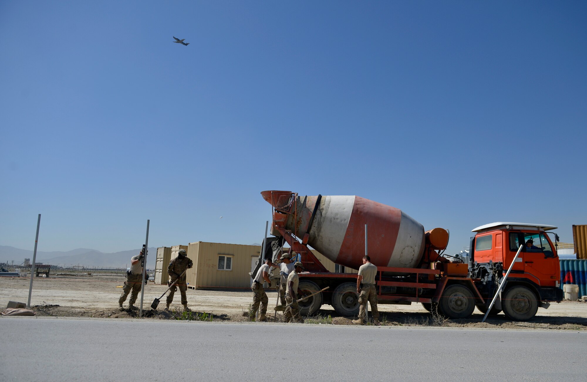 U.S. Air Force Airmen from the 577th Expeditionary Prime Base Engineer Emergency Force Squadron troop constructions, pour cement for a new security fence at Bagram Airfield, Afghanistan May 24, 2014.  The 577th EPBS brings together civil engineering Airmen from across several specialties to perform forward deployed construction work. The squadron is comprised of configured teams who are ready to travel to accomplish assigned missions.  Some of their capabilities include painting airfield layouts, removing built up rubber on runways, constructing large area shelter system and airfield improvement projects. (U.S. Air Force photo by Staff Sgt. Evelyn Chavez)