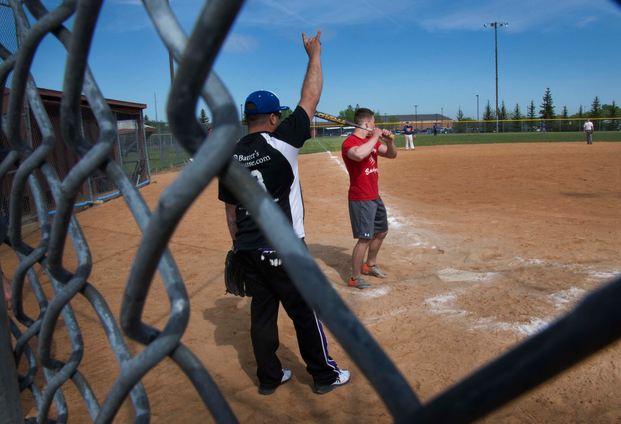 Two teams participate in the National Police Week softball tournament on Minot Air Force Base, N.D., May 31, 2014. National Police Week is meant to strengthen the bond between local law enforcement and military law enforcement, and show appreciation for those who serve the community. (U.S. Air Force photo/Airman 1st Class Lauren Pitts)