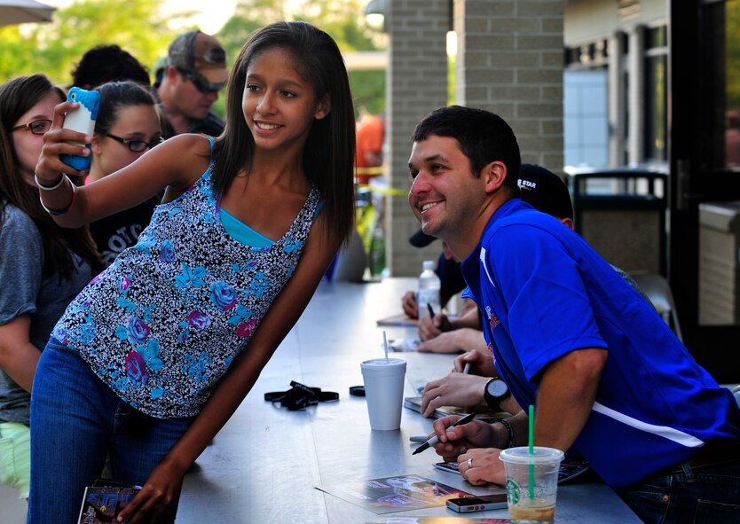 Jazmine Winfield, daughter of Tech. Sgt. Maggie Winfield, 436th Logistics Readiness Squadron, takes a selfie with Reed Sorenson, driver of the No. 36 Tommy Baldwin Racing Chevy, during a Race Weekend Social May 30, 2014 at Mulligans Sports Bar and Grill, Dover Air Force Base, Del. The social is part of a Morale, Welfare and Recreation program coordinated by the 436th Force Support Squadron to bring entertainment to Airmen and their families. (U.S. Air Force photo/Staff Sgt. Elizabeth Morris)