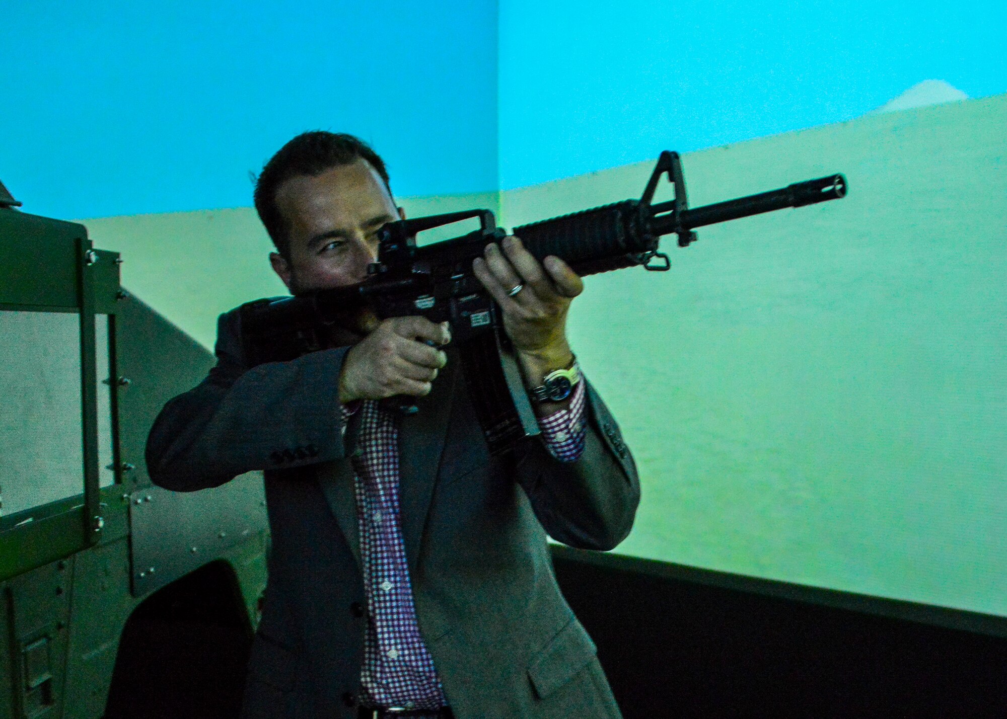 Tony Alexander fires on an enemy combatant inside the convoy simulator at the Naval Construction Training Center Gulfport, Mississippi.  The NCTC visit supplemented the tour for a group of Northwest Florida civic leaders to the Air Force Reserve’s 403rd Wing at Keesler Air Force Base, Mississippi. Each year, the 919th Special Operations Wing invites local civic leaders on a tour of other Air Force Reserve units to increase their understanding of the diverse missions accomplished by the Reserve and other Department of Defense organizations.  (U.S. Air Force photo/Tech. Sgt. Cheryl Foster)