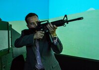 Tony Alexander fires on an enemy combatant inside the convoy simulator at the Naval Construction Training Center Gulfport, Mississippi.  The NCTC visit supplemented the tour for a group of Northwest Florida civic leaders to the Air Force Reserve’s 403rd Wing at Keesler Air Force Base, Mississippi. Each year, the 919th Special Operations Wing invites local civic leaders on a tour of other Air Force Reserve units to increase their understanding of the diverse missions accomplished by the Reserve and other Department of Defense organizations.  (U.S. Air Force photo/Tech. Sgt. Cheryl Foster)