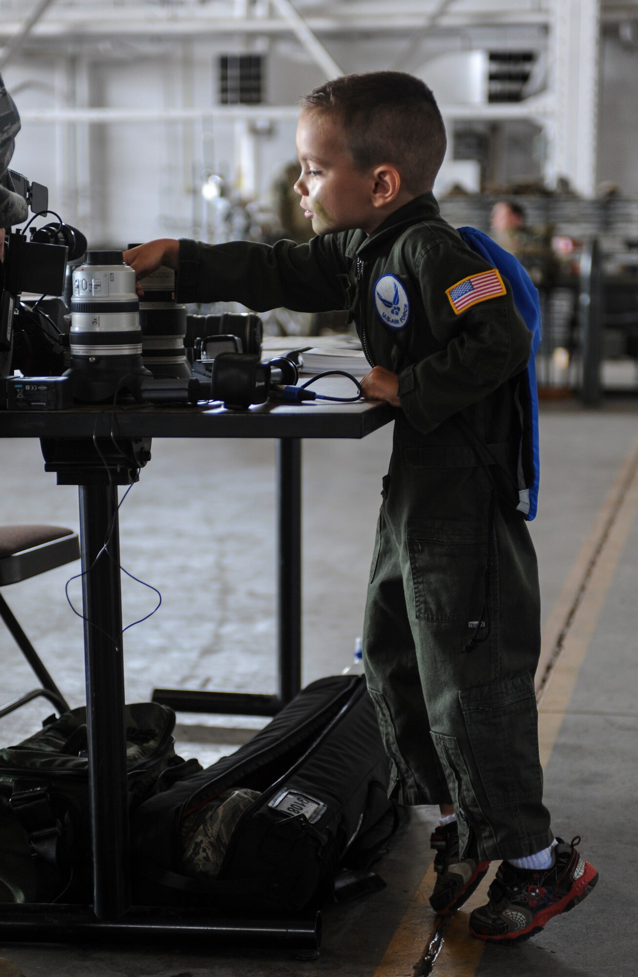 Noah Badger, son of 1st Lt. Eric Badger, 5th Medical Support Squadron medical information services flight commander, views audio equipment at a Public Affairs display during Operation Heroes at Minot Air Force Base, N.D., May 31, 2014. Badger also toured the inside of a B-52H which he had properly dressed for as he sported a miniature version of the Air Force flight suit. (U.S. Air Force Photo/Senior Airman Stephanie Morris)