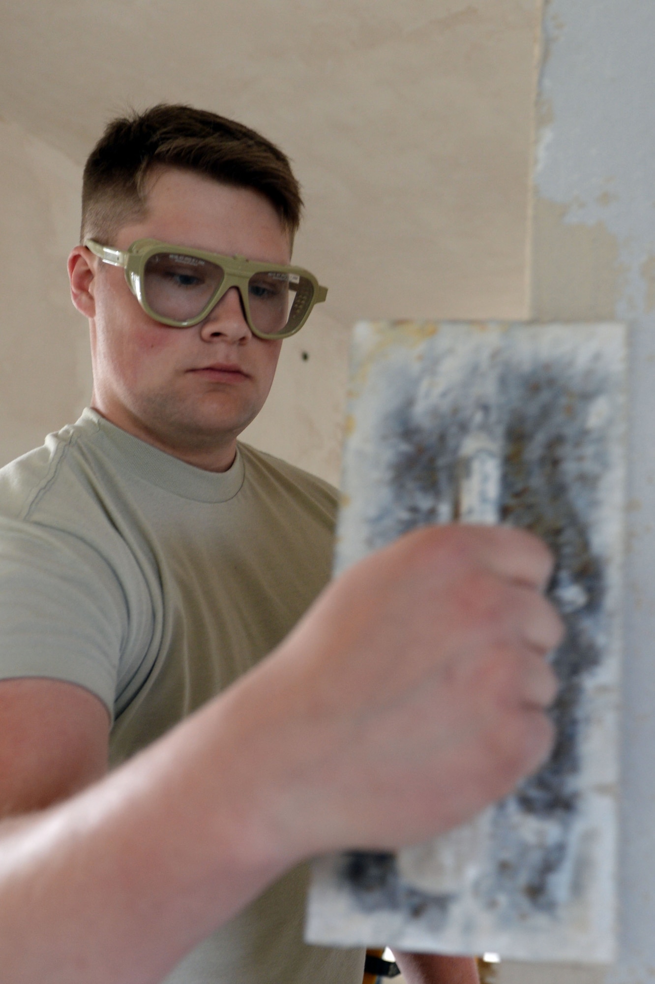 U.S. Air Force Airman 1st Class Lane Kocian, 52nd Civil Engineer Squadron structures journeyman from Luise, Texas, plasters a doorway in an unused building at Spangdahlem Air Base, Germany, June 3, 2014. Structures Airmen have been working this project for almost a month. (U.S. Air Force photo by Senior Airman Alexis Siekert/Released)