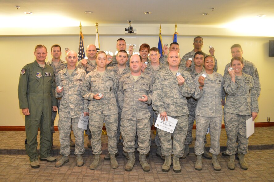 OSAN AIR BASE, Republic of Korea - Members of Team Osan hold up challenge coins presented to them by Brig. Gen. Russell Mack, 7th Air Force vice commander, for their exceptional work during Exercise Beverly Bulldog June 3, 2014. Beverly Bulldog 14-02 ran May 5-9 and tested both Osan and Kunsan AB's ability to operate during contingency operations. (U.S. Air Force photo by Tech. Sgt. Thomas J. Doscher)