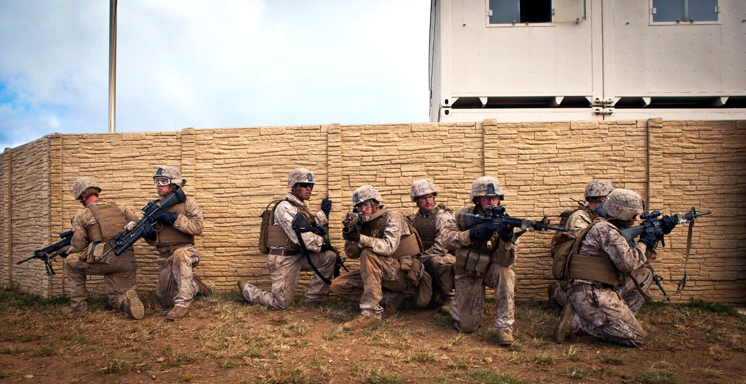Marines provide security outside of a compound wall during a search and rescue mission at the Boondocker Training Area on Marine Corps Base, Hawaii, May 28, 2014.