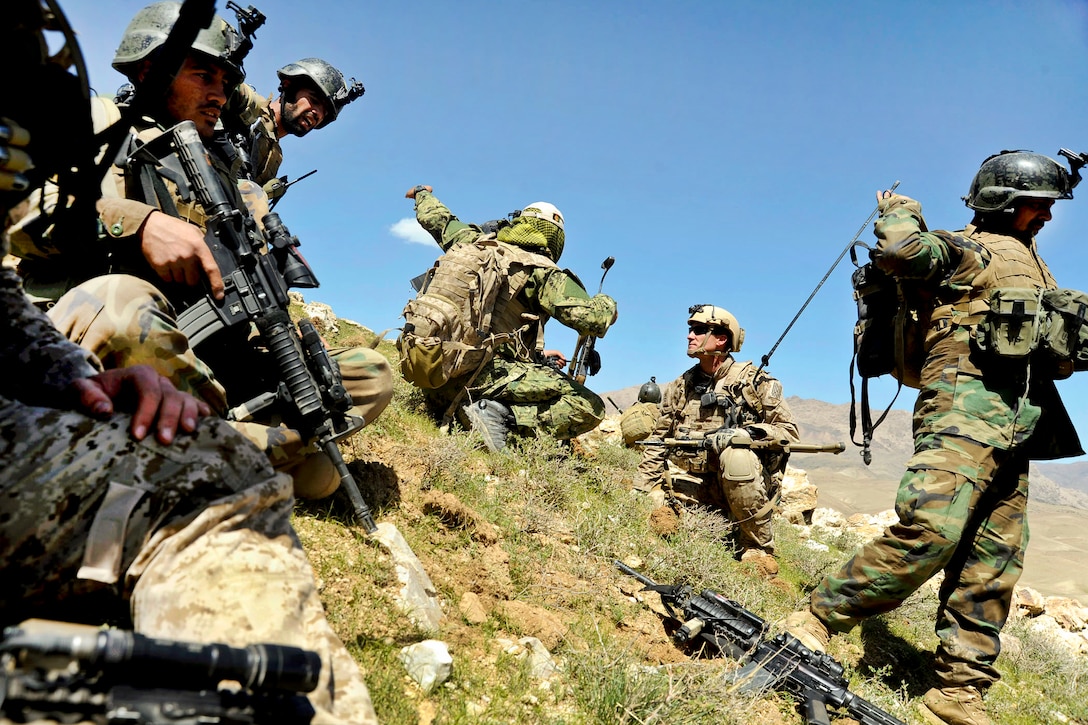 Afghan soldiers and coalition special operations forces discuss troop movement from a hilltop during a firefight near Nawa Garay village in the Kajran district of Afghanistan's Daykundi province, April 3, 2012.  
