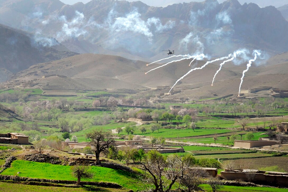 An AH-64 Apache helicopter releases flares over a valley to support coalition special operations forces and Afghan soldiers during a firefight near Nawa Garay village in the Kajran district of Afghanistan's Daykundi province, April 3, 2012.  
