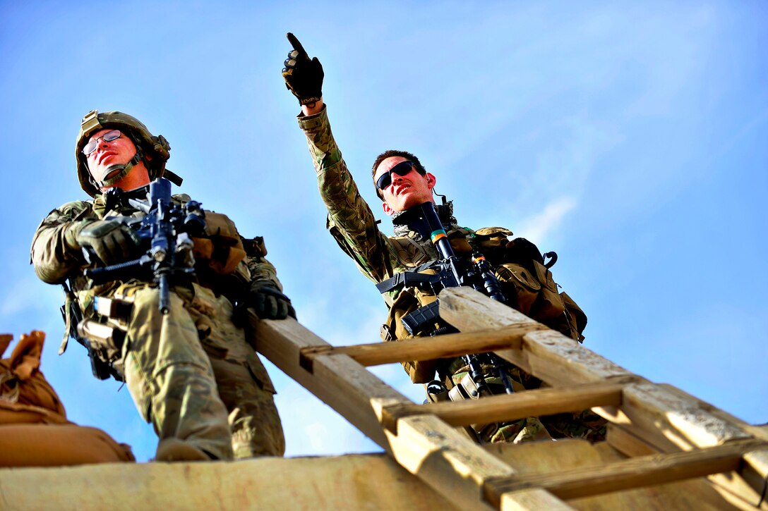 U.S. Army Sgt. Daniel Nelson, right, points out the arrival of an expected convoy to Staff Sgt. Mark Scott on Forward Operating Base Farah in Afghanistan's Farah province, April 7, 2012. Nelson, a squad leader, and Scott are assigned to Provincial Reconstruction Team Farah's security force.  
