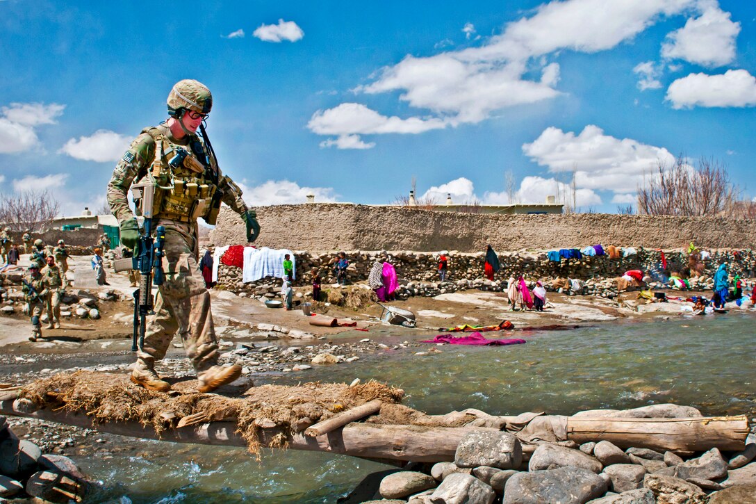 U.S. Army Sgt. Michael Trevino uses a foot bridge to cross a swollen river outside of the village of Marzak in Afghanistan's Paktika province, April 4, 2012. Trevino is assigned to the 172nd Infantry Brigade. Afghans had washed their clothing on the far bank.  
