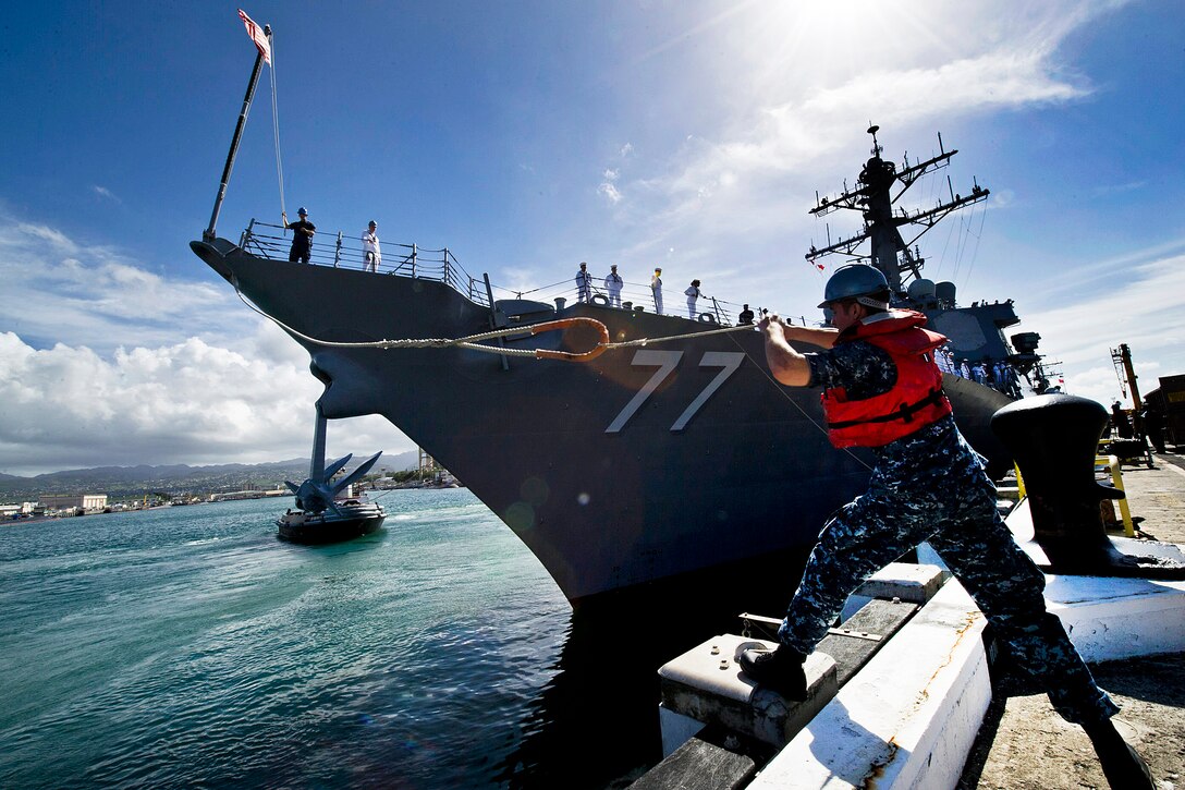 U.S. Navy Petty Officer 2nd Class Joshua Thomas casts a mooring line to sailors aboard the guided-missile destroyer USS O'Kane as it departs Joint Base Pearl Harbor-Hickam, Hawaii, March 23, 2012. O'Kane is deploying under the Middle Pacific Surface Combatant deployment concept, in which Pearl Harbor-based ships deploy in support of operations primarily in the western Pacific region.  
