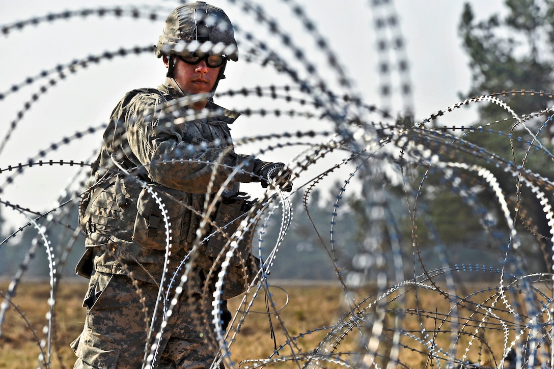 U.S. Army Pvt. Vincent Redondo lays out concertina wire during a situational training exercise at the Grafenwoehr Training Area, Joint Multinational Training Command in Vilseck, Germany, March 22, 2012. Redondo is assigned to Company I, 3rd Squadron, 2nd Cavalry Regiment.  
