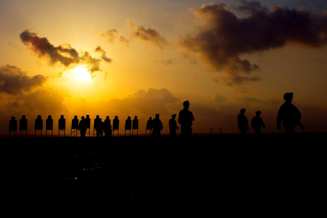 U.S. Marines walk away from training targets after firing small-arms weapons aboard the USS New Orleans under way in the Arabian sea, March 28, 2012.  
