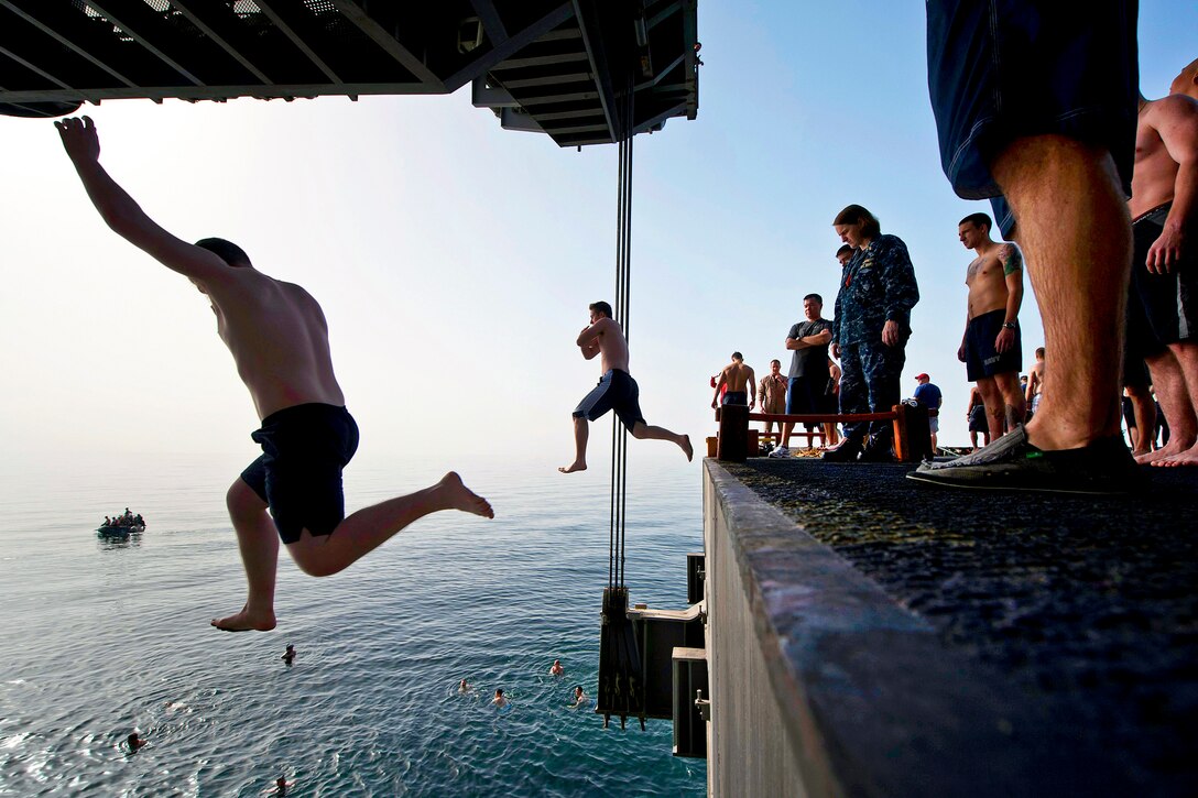 U.S. sailors jump off an aircraft elevator during a swim call aboard the aircraft carrier USS Carl Vinson in the Arabian Sea, March 23, 2012. The Carl Vinson and Carrier Air Wing 17 are deployed to the U.S. 5th Fleet area of responsibility.  
