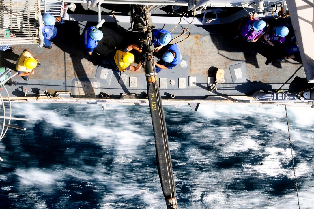 U.S. sailors tie down a refueling probe aboard the USS Bunker Hill during an underway replenishment with the USNS Bridge in the Arabian Sea, March 16, 2012. Bunker Hill is deployed to the U.S. 5th Fleet area of responsibility conducting maritime security operations and theater security operation efforts.  
