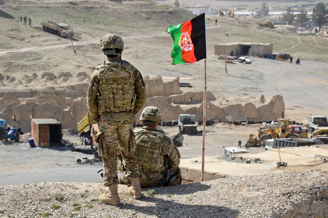 U.S. Army Sgt. Rolan Wade, right, and an interpreter assigned to the Zabul Abribusiness Development Team look on from a hilltop as other team members visit the Qalat Stockyard in Qalat, Afghanistan, March 26, 2012. Wade is assigned to the Mississippi Army National Guard.  
