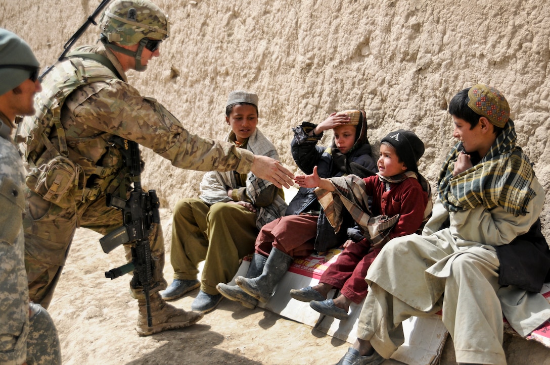 U.S. Army 2nd Lt. Jeffery Russell greets Afghan children in the village Sader Kheyl, Afghanistan, March 17, 2012. Russell is a platoon leader assigned to Company B, 3rd Battalion, 509th Infantry Regiment.  
