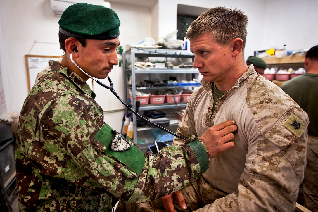 Afghan army Pvt. Samad Khan, a medic, checks the heartbeat of U.S. Navy Petty Officer 2nd Class Seth Michaelis during the final examination of an eight-week medic course for Afghan soldiers on Forward Operating Base Delhi in Afghanistan's Helmand province, March 9, 2012. Corpsmen with "America's Battalion" led the course, which was the first for Afghan soldiers in Garmsir district. Michaelis is assigned to the 3rd Battalion, 3rd Marine Regiment.  
