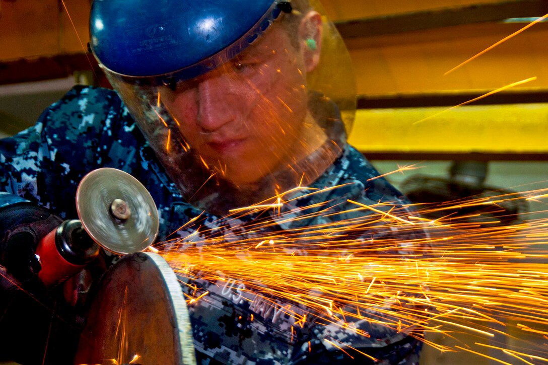 U.S. Navy Seaman Ryan Renneker grinds a blank flange for a seawater cooler on one of the diesel engines of the amphibious assault ship USS Makin Island in the Arabian Sea, March 1, 2012. The Makin Island and embarked Marines assigned to the 11th Marine Expeditionary Unit are deployed supporting maritime security operations and theater security cooperation efforts in the U.S. 5th Fleet area of responsibility. Renneker is a hull maintenance technician fireman.  
