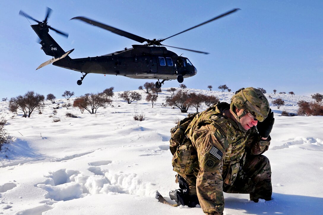 U.S. Army Sgt. 1st Class Shawn Joyce shields his face from blowing snow and rotor as a UH-60 Black Hawk helicopter lands nearby in Afghanistan's Parwan province, March 1, 2012. Joyce is a career counselor assigned to Task Force Poseidon.  
