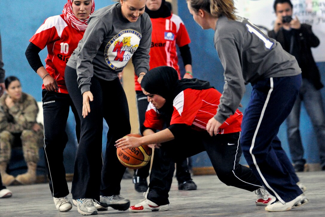 A member of an Afghan women’s Olympic basketball team recovers the ball after a rebound during an exhibition match with members of the International Security Assistance Force and U.S. Embassy team at the force's headquarters in Kabul, Afghanistan, March 7, 2012. The match marked International Women’s Day and recognized the talent and dedication of Afghanistan’s growing number of female athletes.  
