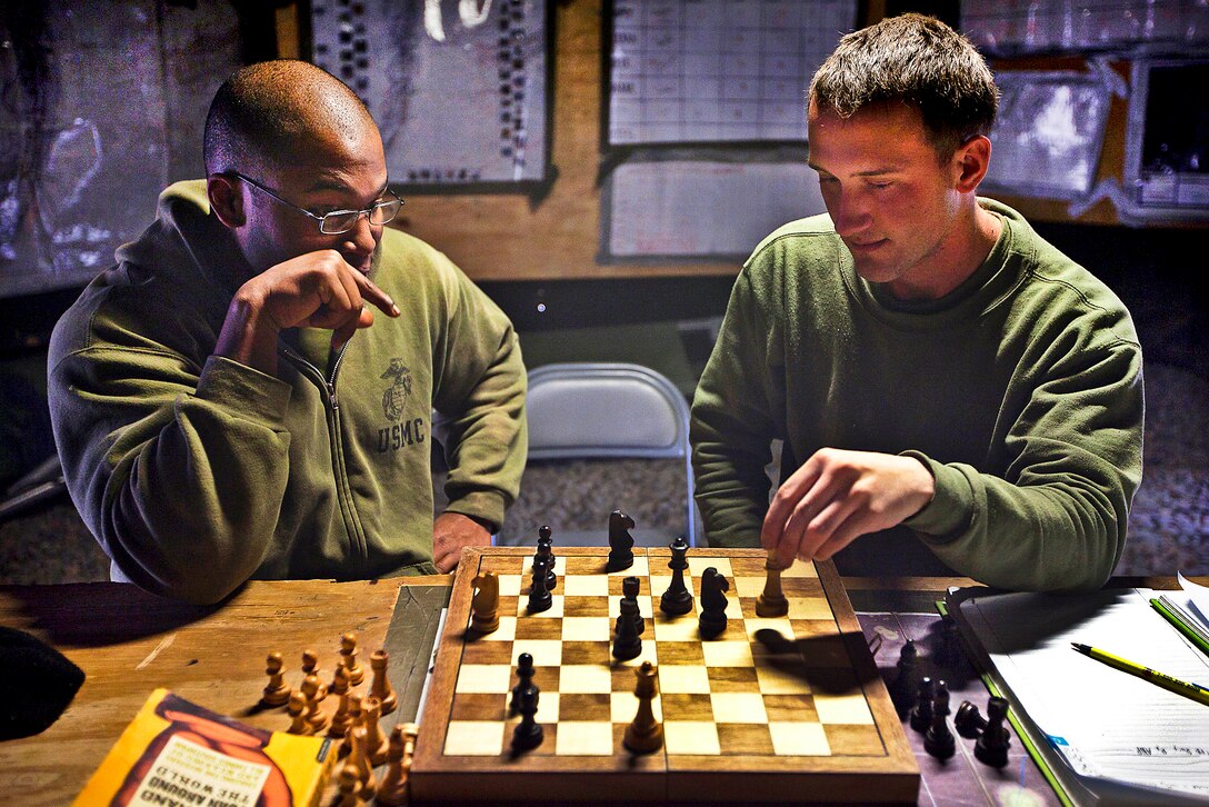 U.S. Marine Sgt. Jeremy Scott, left, and Lance Cpl. Tyler Dickinson play chess after work on Patrol Base Bury in the Garmsir district in Afghanistan's Helmand province, Feb. 26, 2012. Scott, a squad leader, and Dickinson, an assaultman, are assigned to Kilo Company, 3rd Battaltion, 3rd Marine Regiment.  
