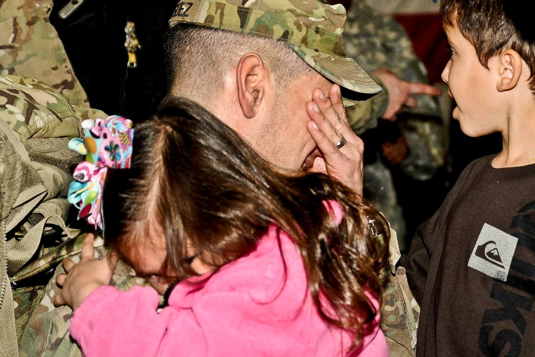 A soldier receives a hug from his daughter on Fort Bragg, N.C., March 1, 2012. Family and friends greeted soldiers assigned to the 44th Medical Brigade, XVIII Airborne Corps who were returning home after a yearlong deployment in Afghanistan.  
