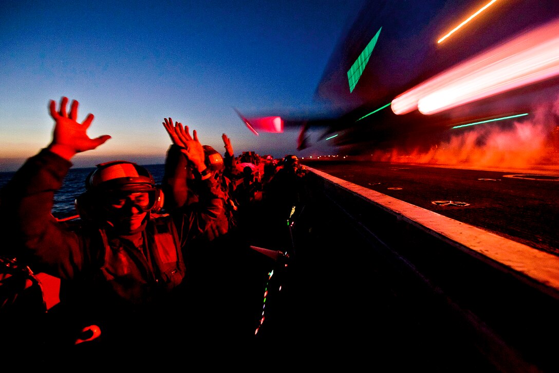 U.S. Navy Petty Officer 2nd Class Blas Manzanares shows his hands are clear of the control panel as he launches an F/A-18C Hornet while operating the waist catapults on the flight deck of the aircraft carrier USS Carl Vinson in the Arabian Gulf, Feb. 22, 2012. Manzanares is an aviation boatswain's mate equipment.  
