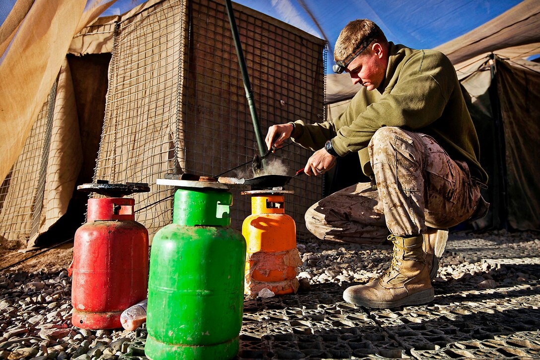 U.S. Marine Corps Lance Cpl. Tom Morton cooks eggs for breakfast before beginning his duties on Patrol Base Bury in the Garmsir district of Afghanistan's Helmand province, Feb. 25, 2012. Morton is a team leader assigned to Kilo Company, 3rd Battalion, 3rd Marine Regiment.  
