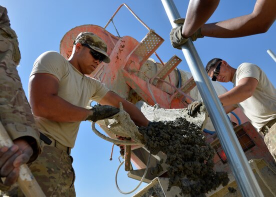 (From left) U.S. Air Force Airman 1st Class Patrick, deployed from Davis-Monthan Air Force Base, Ariz., and Senior Airman Matthew, 577th Expeditionary Prime Base Engineer Emergency Force Squadron troops constructions, pour cement for a new airfield security fence at Bagram Airfield, Afghanistan May 24, 2014. D-M AFB Airmen created an innovative tool, named the Blue Line Tracker, for leadership to track their Airmen downrange. The tracker is now being used at multiple bases across Air Combat Command. (U.S. Air Force photo by Staff Sgt. Evelyn Chavez/Released)