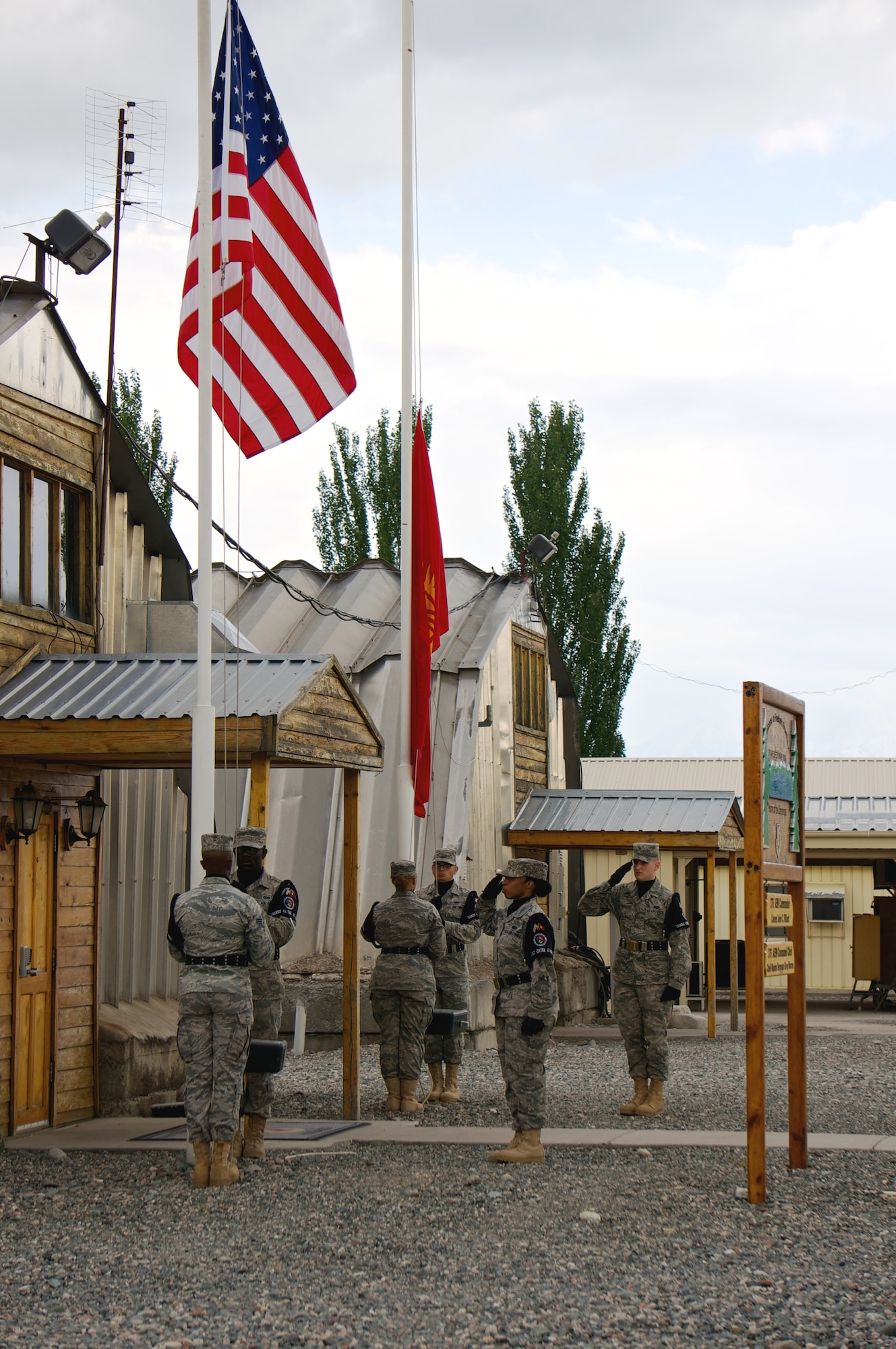 Honor Guard Airmen lower the United States and Kyrgyz Republic flags as part of the 376th Air Expeditionary Wing inactivation ceremony June 3, 2014, at transit center at Manas, Kyrgyzstan. Airmen assigned to the Transit Center during its tenure loaded and flew 42,000 airlift missions, hauling 1.4 billion pounds of cargo. (Courtesy photo/Capt. Cory O'Brien)