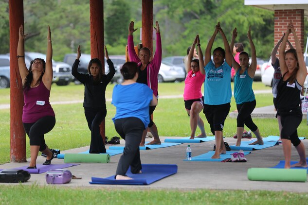 Marine spouses participate in yoga at Ordnance Point Park, Marine Corps Air Station Cherry Point, N.C., May 30, 2014. Vicky Lee, the Semper Fit personal training coordinator, instructed the yoga class, which was scheduled along with paddle boarding and kayaking for Marine Corps Family Team Building's Spouses Outdoor Exploration Day. MCFTB hosted the event to give spouses a day off from the everyday challenges of living a military lifestyle. 