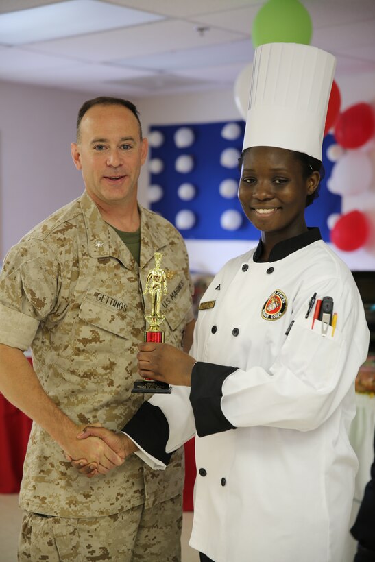 Lance Cpl. Bianca Sanders receives the first place trophy from Lt. Col. Jeremy L. Gettings after winning the Chef of the Quarter competition at Marine Corps Air Station Cherry Point, N.C., May 29, 2014. During the competition, the competitors where tested on the way they prepared and presented their food, as well as their basic knowledge of being a food service specialist. Gettings is the commanding officer of Headquarters and Headquarters Squadron. Sanders is a food service specialist with Marine Wing Support Squadron 271. 