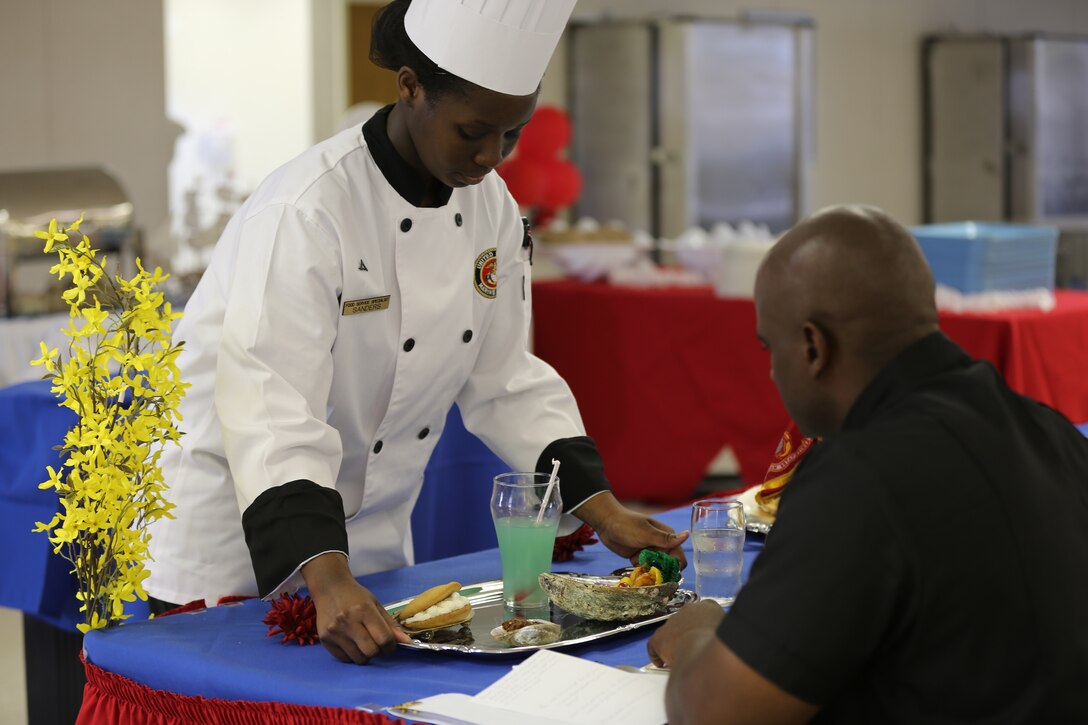 Lance Cpl. Bianca Sanders serves a judge during the Chef of the Quarter competition at Marine Corps Air Station Cherry Point, N.C., May 29, 2014. During the competition, four judges asked each competitor specific questions to test their knowledge and bearing. The judges graded the Marines' performance both in the kitchen and during a final interview and tasting of food. Sanders is a food service specialist with Marine Wing Support Squadron 271.