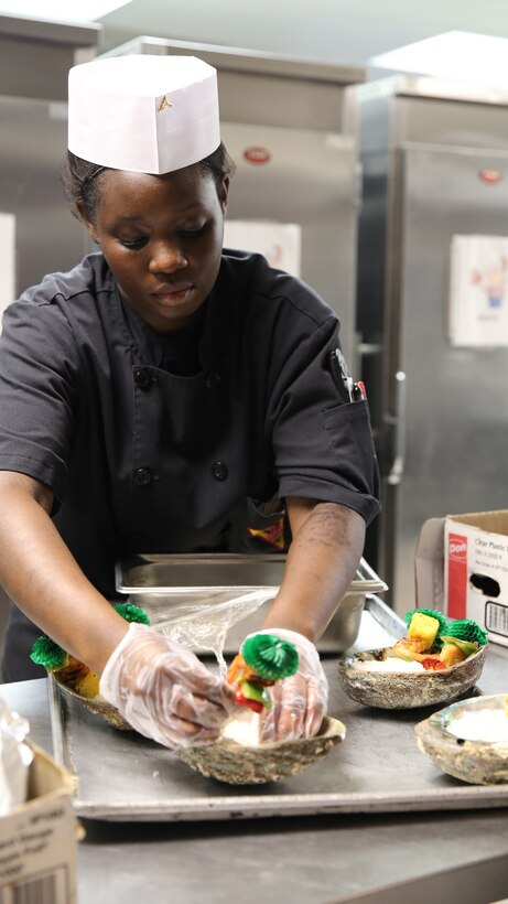 Lance Cpl. Bianca Sanders prepares her main entrée for the Chef of the Quarter competition at Marine Corps Air Station Cherry Point, N.C., May 29, 2014. Sanders' theme for the competition was “Beach and Ocean Frenzy.” To present her theme, Sanders used seashells, brightly colored foods and a tea made from orchid extract. Sanders is a food service specialist with Marine Wing Support Squadron 271. 