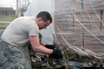 Air Force Staff Sgt. Raymond Graves III, an air cargo specialist with the Kentucky Air National Guard's 123rd Logistics Readiness Squadron, secures cargo netting on a pallet of humanitarian goods bound for Haiti. The Kentucky Air Guard is transporting humanitarian aid items through a program with the U.S. Agency for Internal Development, something they did in 2010 after an earthquake struck the country.